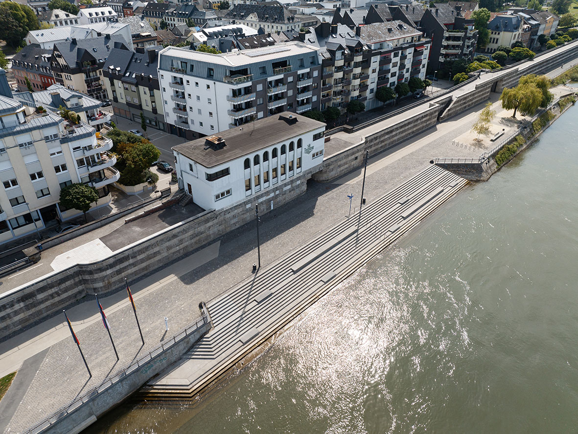 Luftaufnahme: Die Deichkrone thront auf dem Deich und schafft eine Verbindung zwischen Stadt und Rhein.