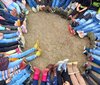 Eine Gruppe Kinder sitzt auf dem Boden und bildet mit Beinen und Füßen einen Kreis.