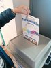 Eine Hand wirft einen Wahlzettel in eine Wahlurne.